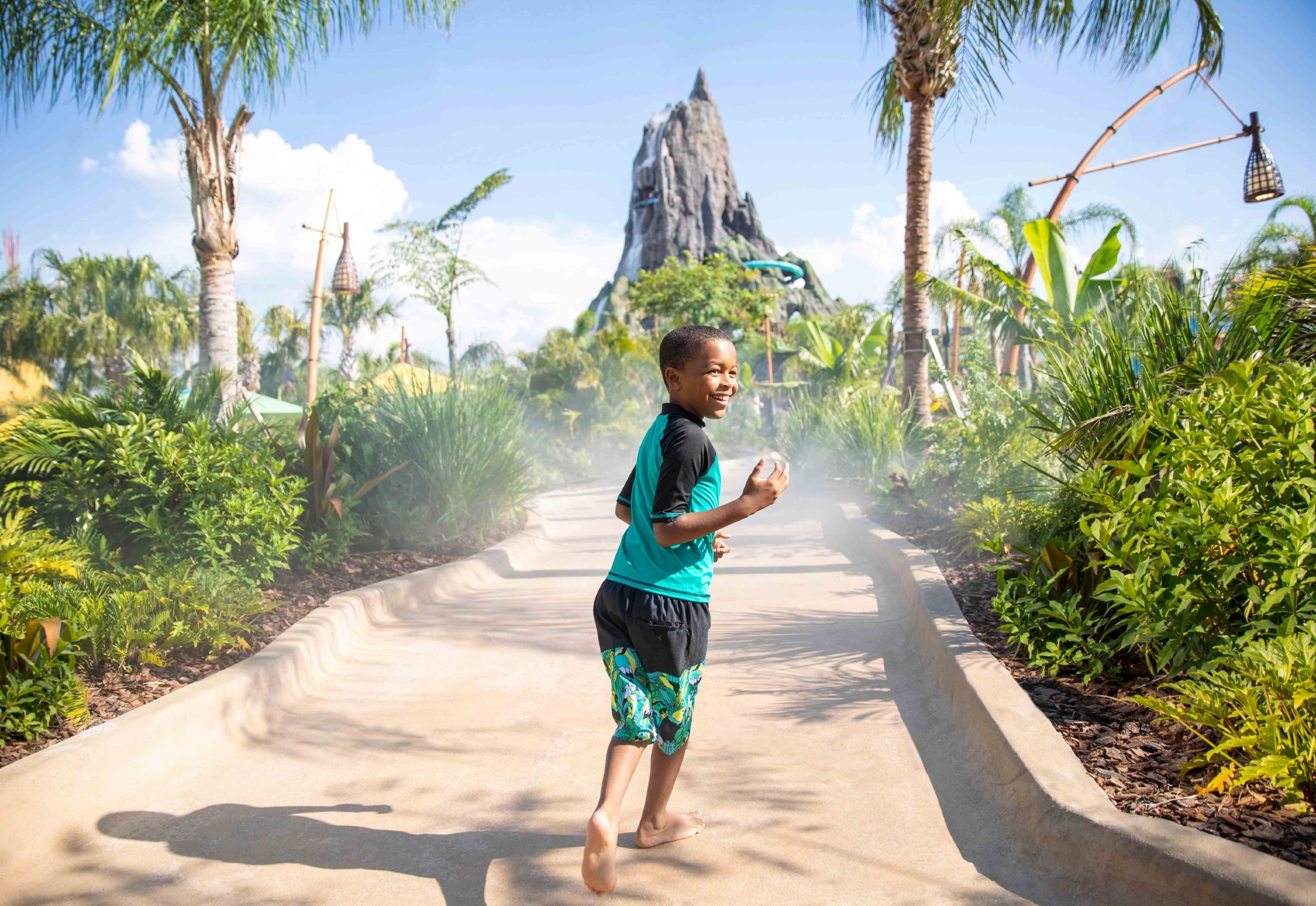 a child running down the path of an amusement park