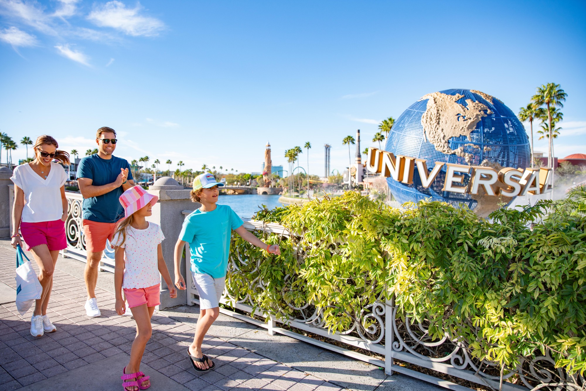 A father and two children exploring Universal Orlando theme park. In the background the Universal globe statue can be seen.