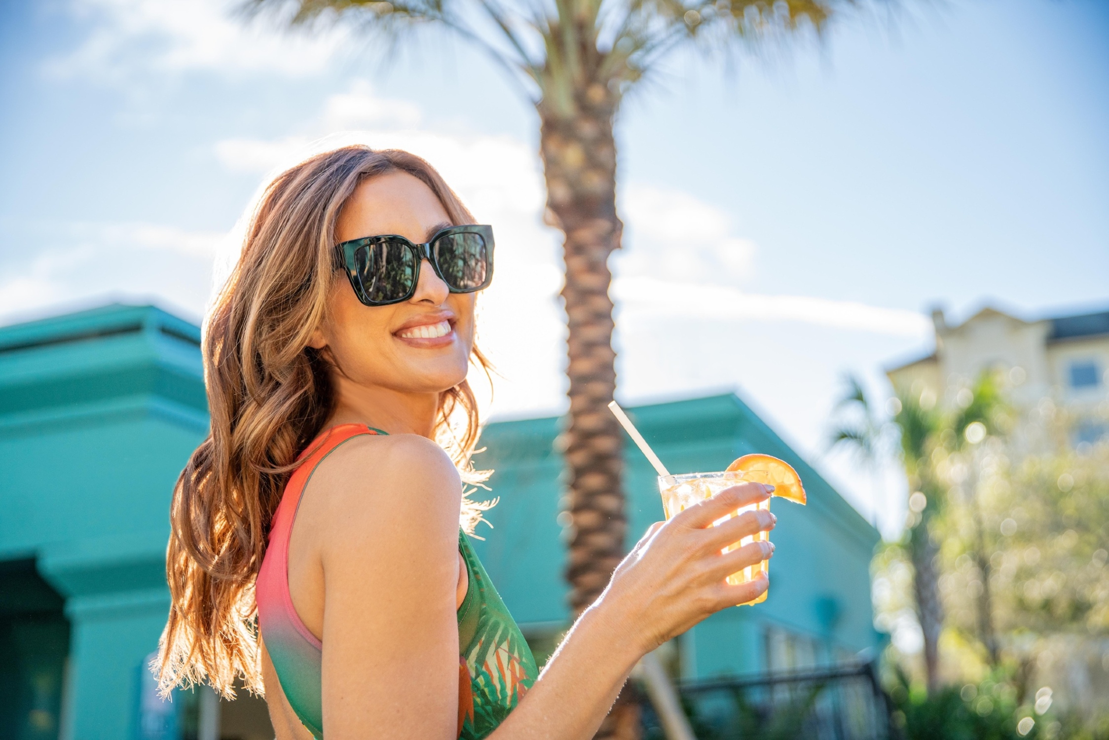 woman wearing sunglasses, enjoying a drink