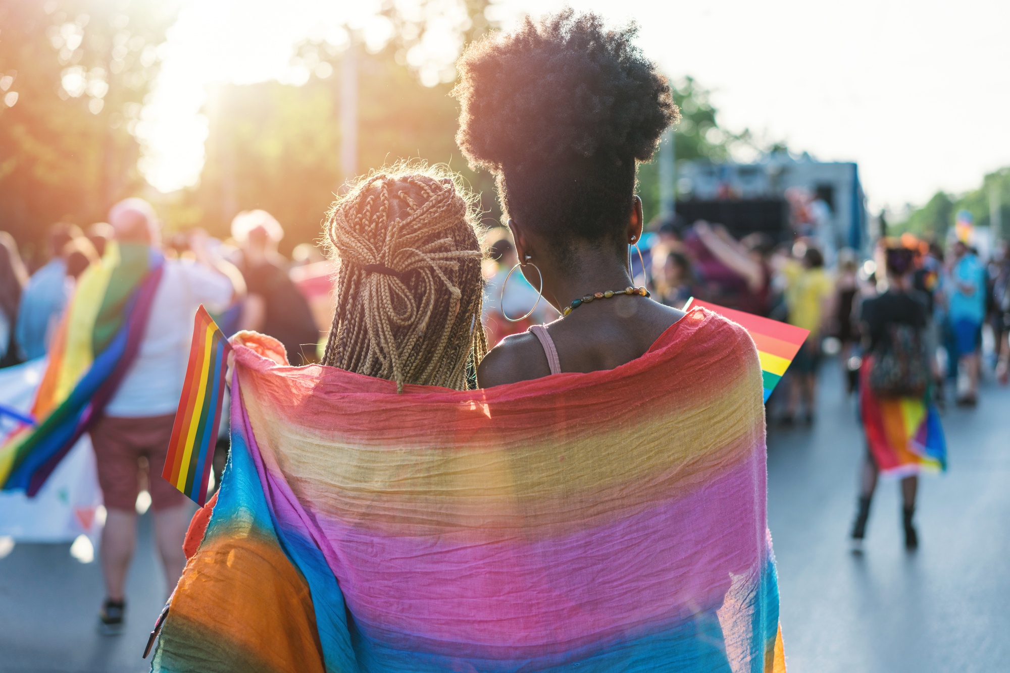 two women wrapped in a pride flag